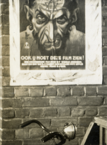 97788 Afbeelding van het affiche met de tekst 'de eeuwige/ Jood/ ook u moet deze film zien!', aangeplakt op een muur te ...